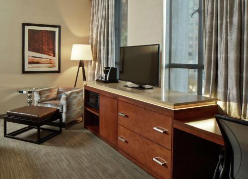 a hotel room with a television on a desk with a chair at Hilton Garden Inn Phoenix Downtown in Phoenix
