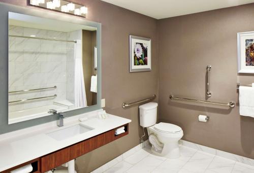 a bathroom with a toilet and a sink and a mirror at Hilton Garden Inn Phoenix Downtown in Phoenix
