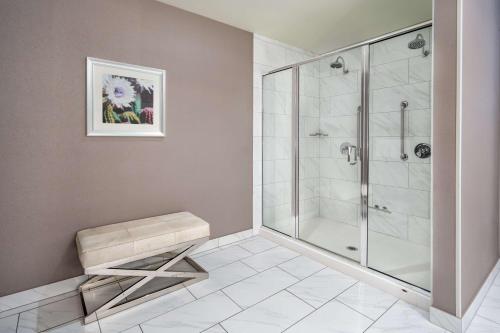 a bathroom with a walk in shower and a bench at Hilton Garden Inn Phoenix Downtown in Phoenix