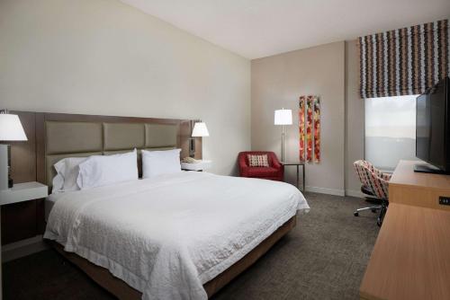 a hotel room with a bed and a television at Hampton Inn Glendale-Peoria in Peoria