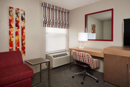 a hotel room with a desk and a red chair at Hampton Inn Glendale-Peoria in Peoria