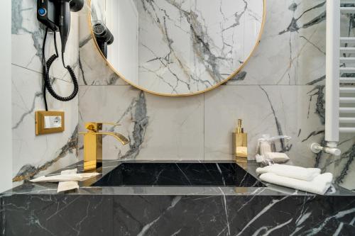 a bathroom with a gold sink and a mirror at Maison 31 -Luxury Apartments in Santa Marinella