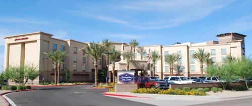 a hotel with cars parked in a parking lot at Hampton Inn & Suites Phoenix/Gilbert in Gilbert