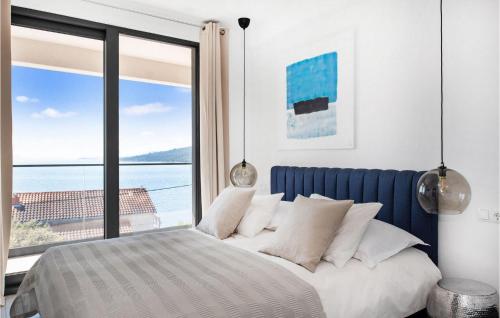 a bedroom with a bed with a view of the ocean at White Palm Villa in Seget Vranjica