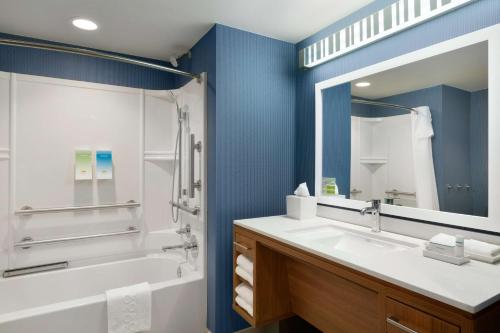 a bathroom with a tub and a sink and a mirror at Home2 Suites By Hilton Glendale Westgate in Glendale