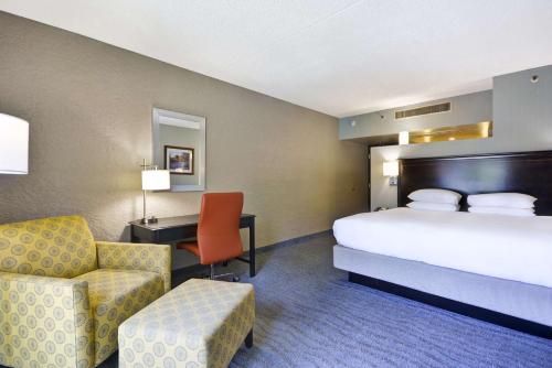 a hotel room with a bed and a desk and a chair at DoubleTree by Hilton Phoenix North in Phoenix