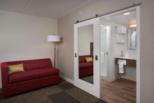 uma sala de estar com um sofá vermelho e um espelho em Hampton Inn & Suites Scottsdale On Shea Blvd em Scottsdale