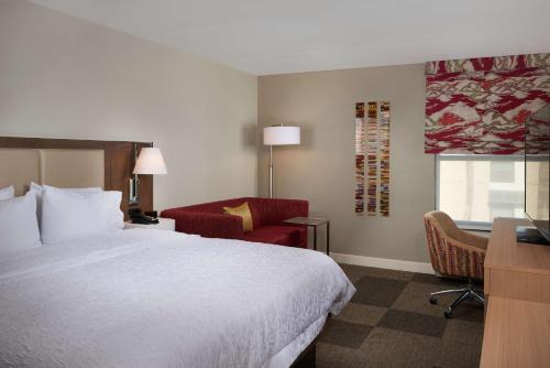 a hotel room with a bed and a chair and a desk at Hampton Inn & Suites Scottsdale On Shea Blvd in Scottsdale