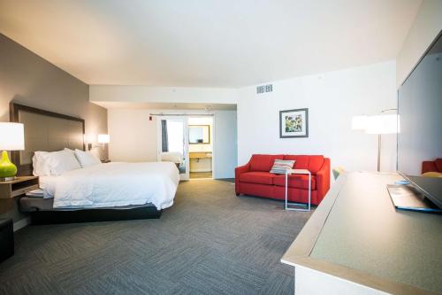 een hotelkamer met een bed en een rode stoel bij Hampton Inn & Suites Tempe/Phoenix Airport, Az in Tempe