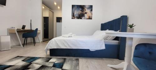 a bedroom with a bed and a desk in a room at Elysian Urbanscape BLUE, near Bucharest in Roşu