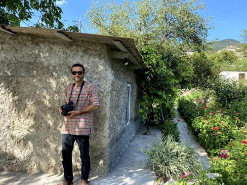a man standing next to a building holding a camera at Old Farm in Ijevan