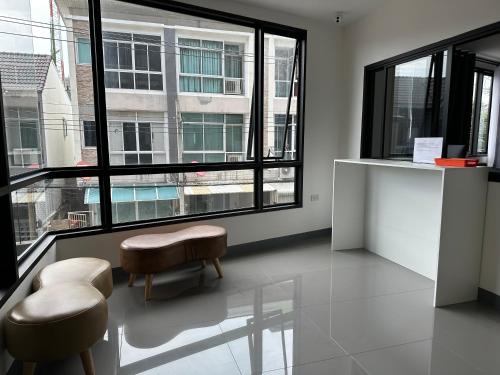 a room with two stools and a large window at D Night Suite Hotel in Bangkok