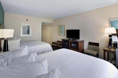 a hotel room with two beds and a flat screen tv at Hampton Inn Bridgeville in Bridgeville