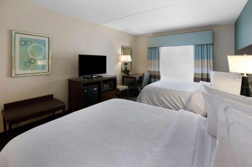 a hotel room with two beds and a flat screen tv at Hampton Inn Bridgeville in Bridgeville
