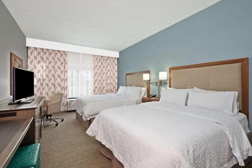 a hotel room with two beds and a flat screen tv at Hampton Inn & Suites North Huntingdon-Irwin, PA in Irwin
