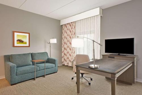 a living room with a couch and a tv at Hampton Inn & Suites North Huntingdon-Irwin, PA in Irwin