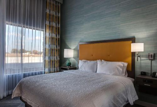 a bedroom with a bed and a large window at Hampton Inn & Suites North Huntingdon-Irwin, PA in Irwin