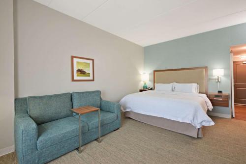 a hotel room with a bed and a couch at Hampton Inn & Suites North Huntingdon-Irwin, PA in Irwin