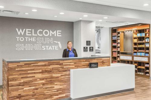 a woman standing behind a counter in a store at Hampton Inn Odessa Trinity in Odessa