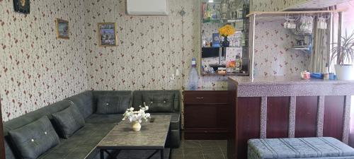 Дача Уют Чарвак Узбекистан في Chorwoq: غرفة معيشة مع أريكة وطاولة