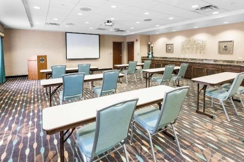 a conference room with tables and chairs and a screen at Hampton Inn Bridgeville in Bridgeville