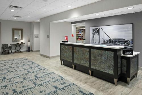 a lobby with a large tv and a bridge on the wall at Hampton Inn & Suites Cranberry Township/Mars in Cranberry Township