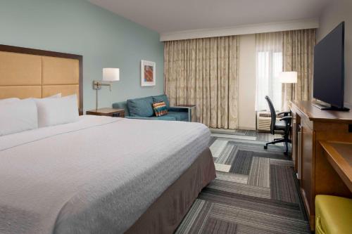 Hampton Inn Pittsburgh-Monroeville في مونروفيل: غرفة فندقية بسرير وتلفزيون بشاشة مسطحة