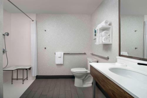 a bathroom with a white toilet and a sink at Hampton Inn Pittsburgh-Monroeville in Monroeville