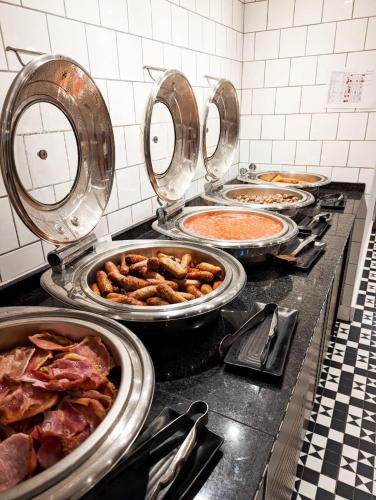 a kitchen with many pans of food on a counter at DoubleTree by Hilton Bristol South - Cadbury House in Yatton
