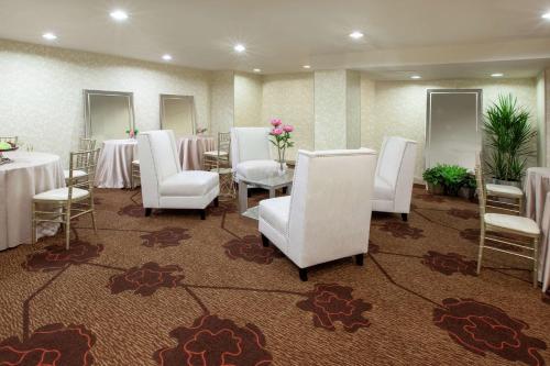 a conference room with white chairs and tables and mirrors at Hilton Garden Inn Pittsburgh University Place in Pittsburgh