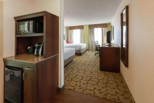 a hotel room with a bedroom with a bed and a television at Hilton Garden Inn Pittsburgh University Place in Pittsburgh