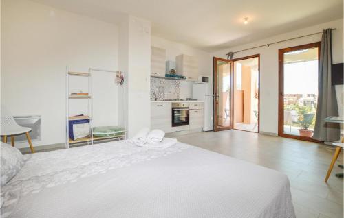 Lovely Apartment In Piana With Wifi في بيانا: غرفة نوم بيضاء مع سرير أبيض ومطبخ