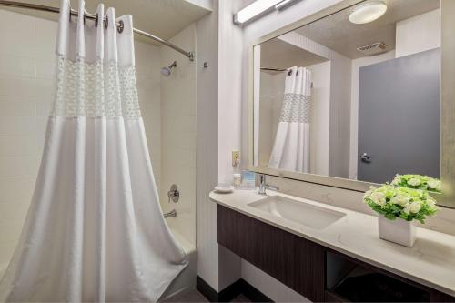 a bathroom with a white shower curtain and a sink at Hampton Inn & Suites Palm Desert in Palm Desert