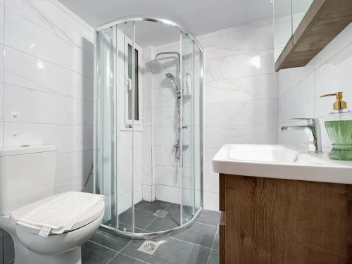 uma casa de banho com um chuveiro, um WC e um lavatório. em 2-bedroom Winter Apartment em Atenas