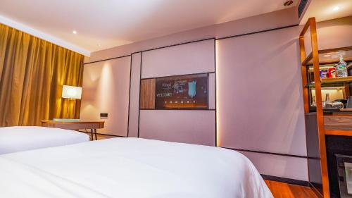 a hotel room with two beds and a tv at FUGO Hotel Samarinda in Samarinda