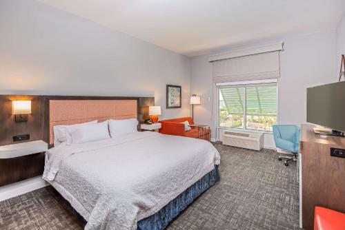 a hotel room with a bed and a flat screen tv at Hampton Inn Pensacola Beach in Pensacola Beach