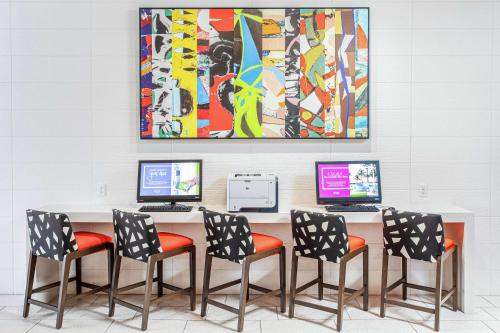 a conference room with four chairs and a table with computers at Hampton Inn Pensacola Beach in Pensacola Beach