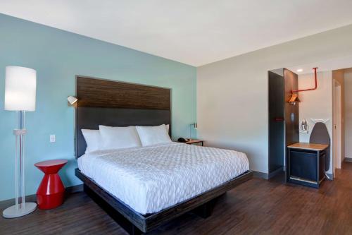 a bedroom with a bed and a red stool at Tru By Hilton Fort Walton Beach, Fl in Fort Walton Beach