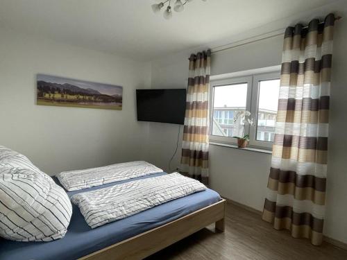 a bedroom with a bed and a tv and a window at Wohnung 13 in Wildeshausen