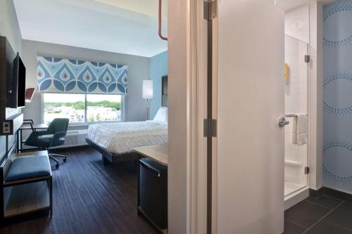 a hotel room with a bed and a desk and a window at Tru By Hilton Fort Walton Beach, Fl in Fort Walton Beach