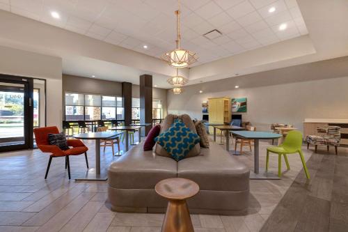 a lobby with a couch and tables and chairs at Home2 Suites by Hilton Gulf Breeze Pensacola Area, FL in Gulf Breeze