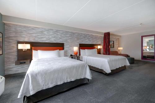 a hotel room with two beds with white sheets at Home2 Suites by Hilton Gulf Breeze Pensacola Area, FL in Gulf Breeze