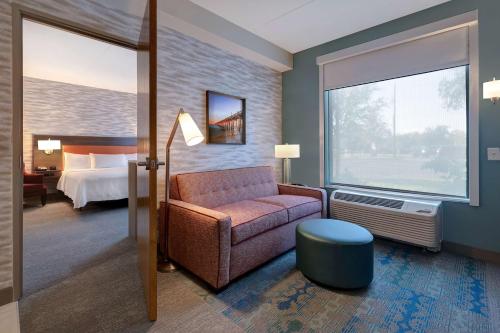 Home2 Suites by Hilton Gulf Breeze Pensacola Area, FL في غولف بريز: غرفة معيشة مع أريكة وسرير
