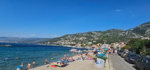 a group of people on a beach near the water at Apartments Klara in Sveti Juraj