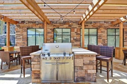 an outdoor kitchen with a grill and tables and chairs at Homewood Suites By Hilton Poughkeepsie in Poughkeepsie