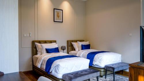 two beds sitting next to each other in a room at Bincarung House Bogor in Bogor