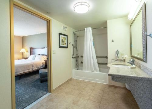 a bathroom with a bed and a tub and a sink at Hampton Inn Presque Isle in Presque Isle