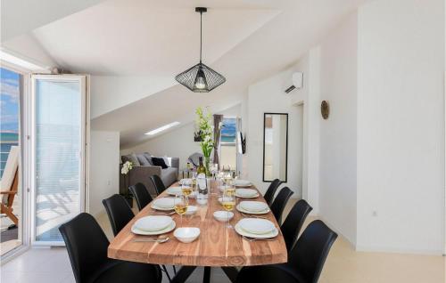 ein Esszimmer mit einem Holztisch und schwarzen Stühlen in der Unterkunft Villa A&M 2 in Nin