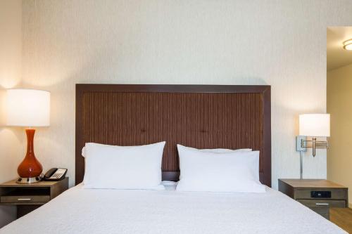 a bedroom with a bed with white sheets and two lamps at Hampton Inn & Suites Pasco/Tri-Cities, WA in West Pasco