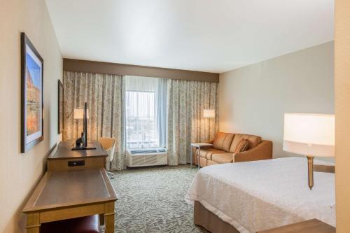 West PascoにあるHampton Inn & Suites Pasco/Tri-Cities, WAのベッドとソファ付きのホテルルーム